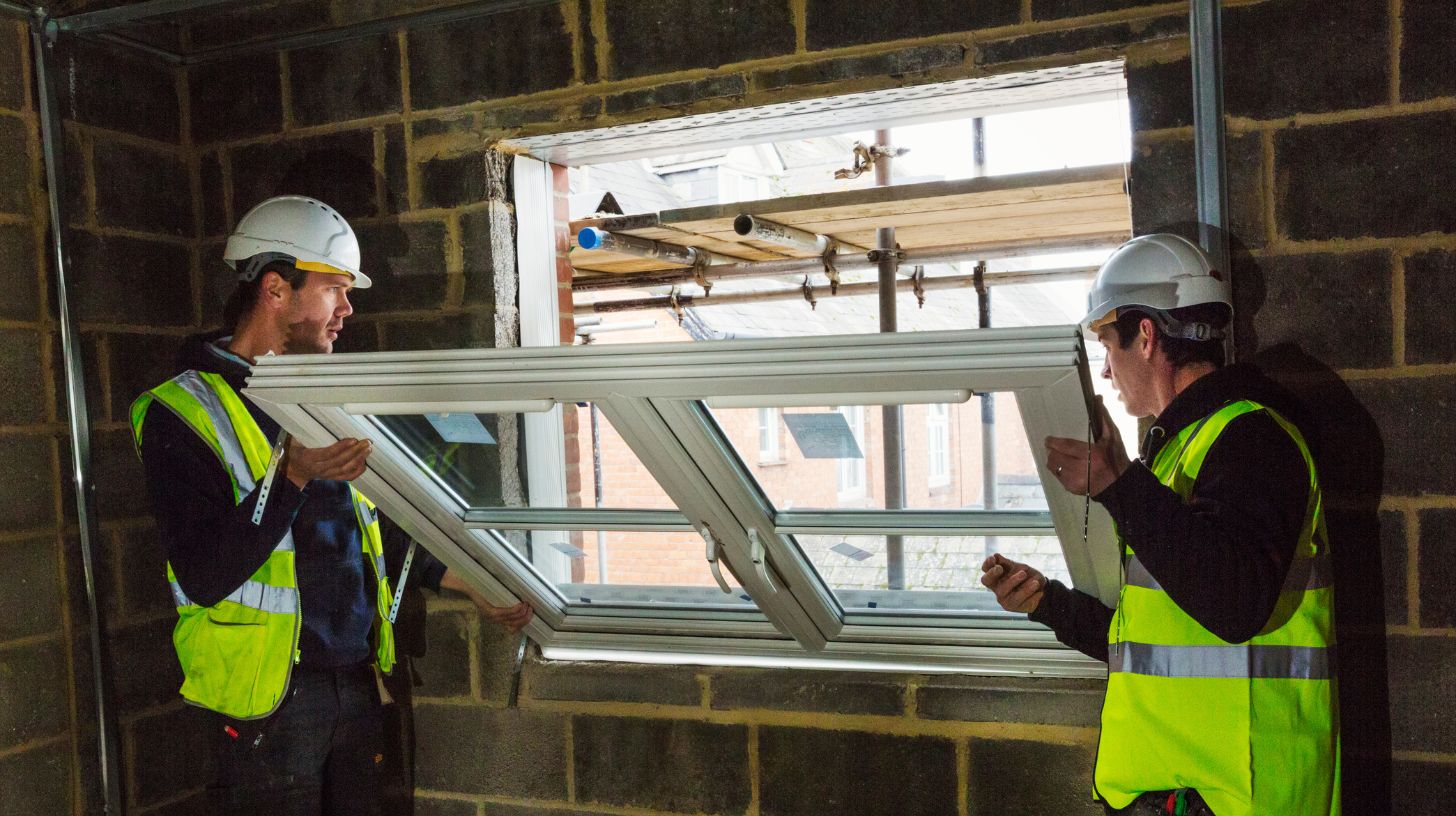 Two window experts installing a uPVC window