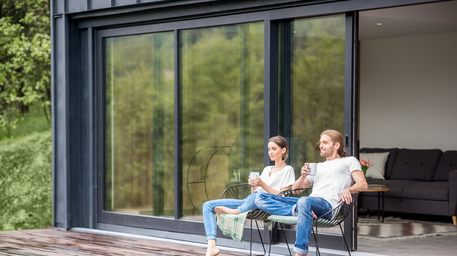 two people sitting on their patio in front of a sliding door